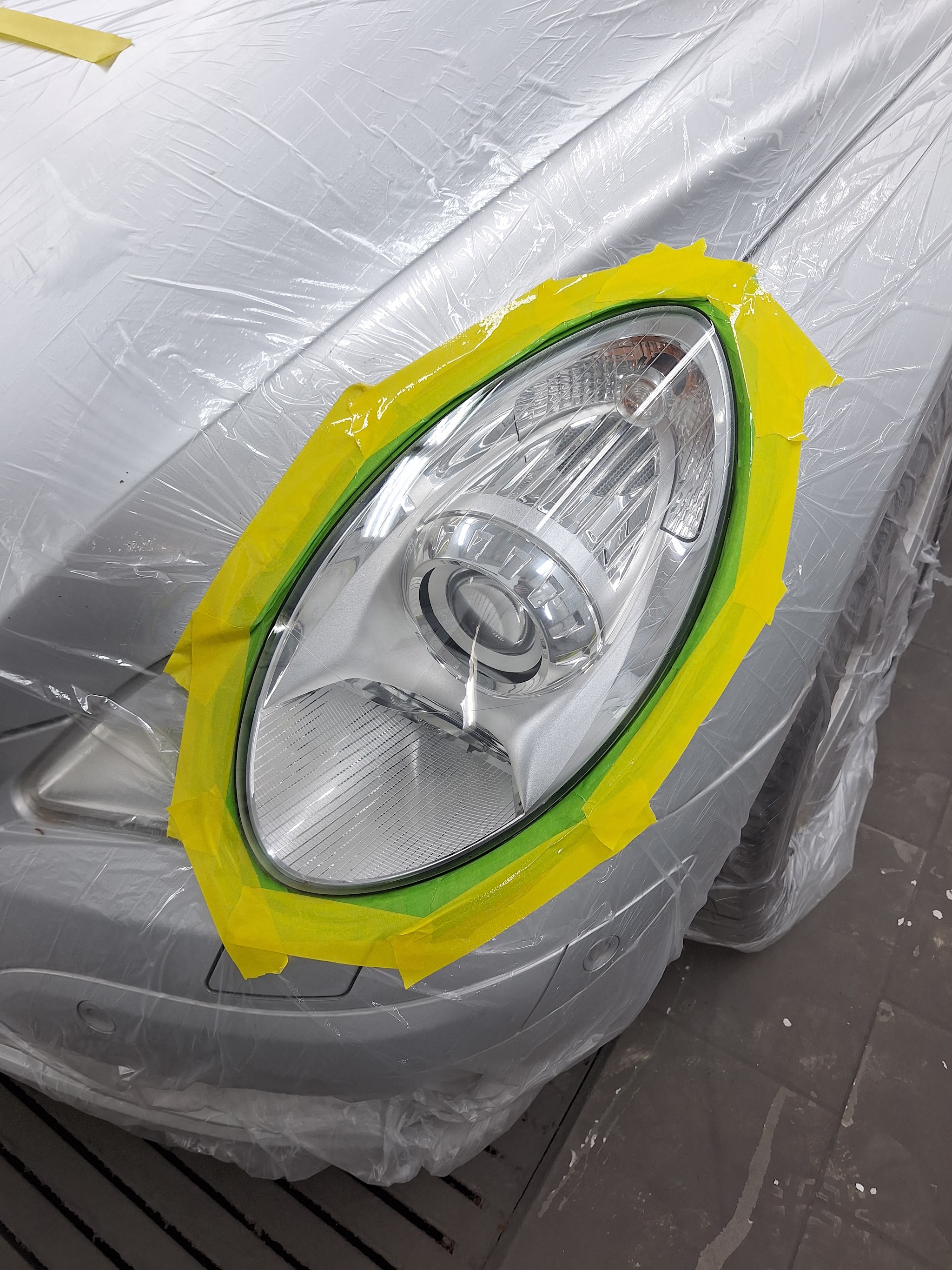 Een koplamp die met gele en groene tape zorgvuldig is afgeplakt