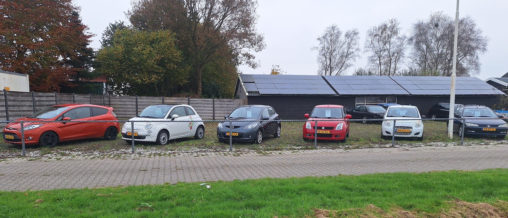 Het terrein van PPL Auto's met een rij occasions naast elkaar